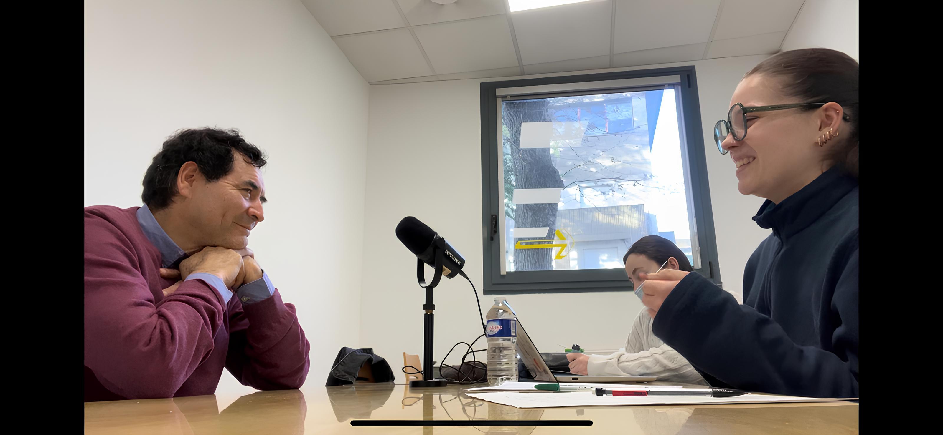 des étudiantes interviewent un professeur devant des micros