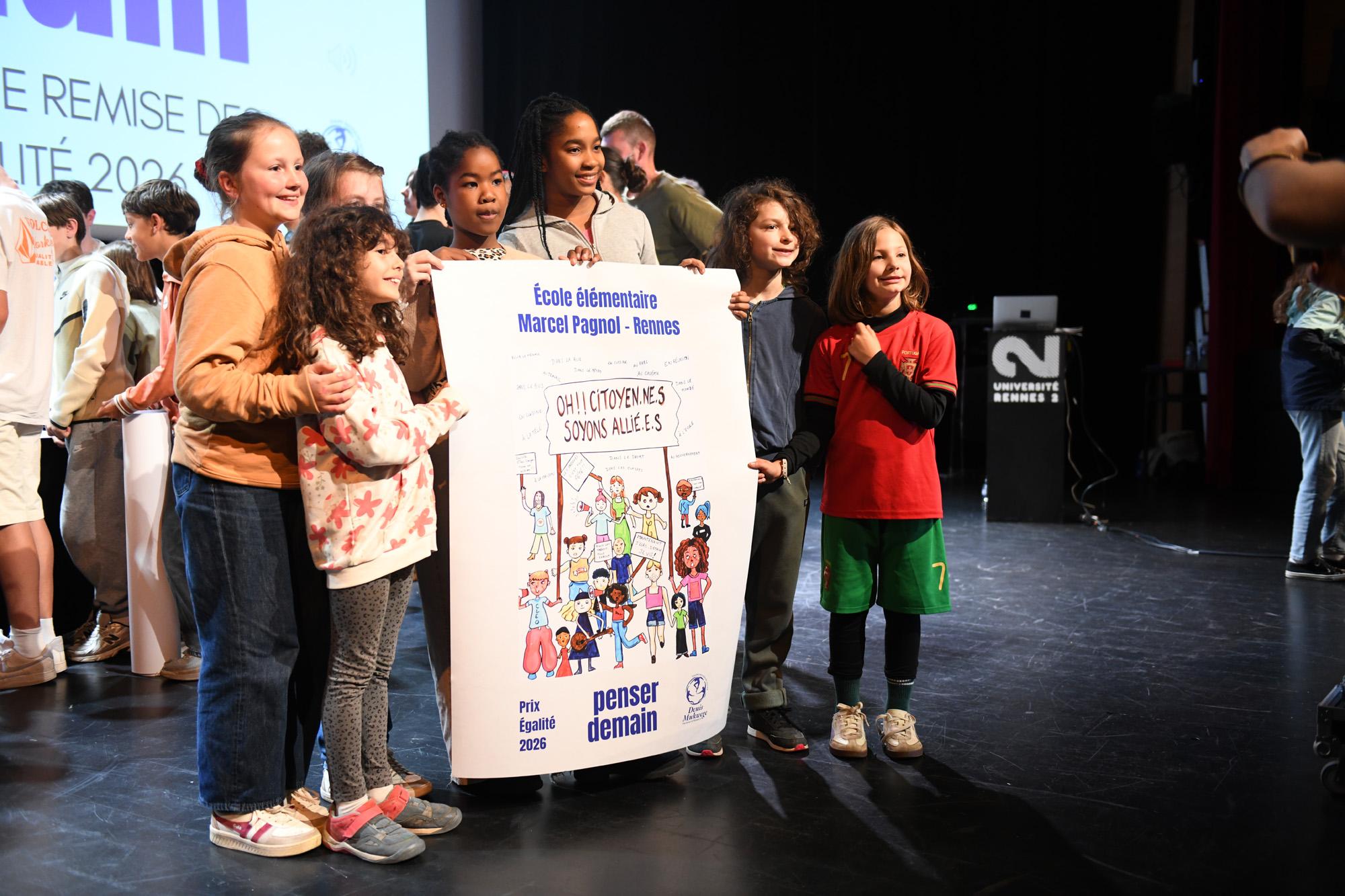 des enfants tiennent fièrement une affiche qu'ils et elles ont réalisée