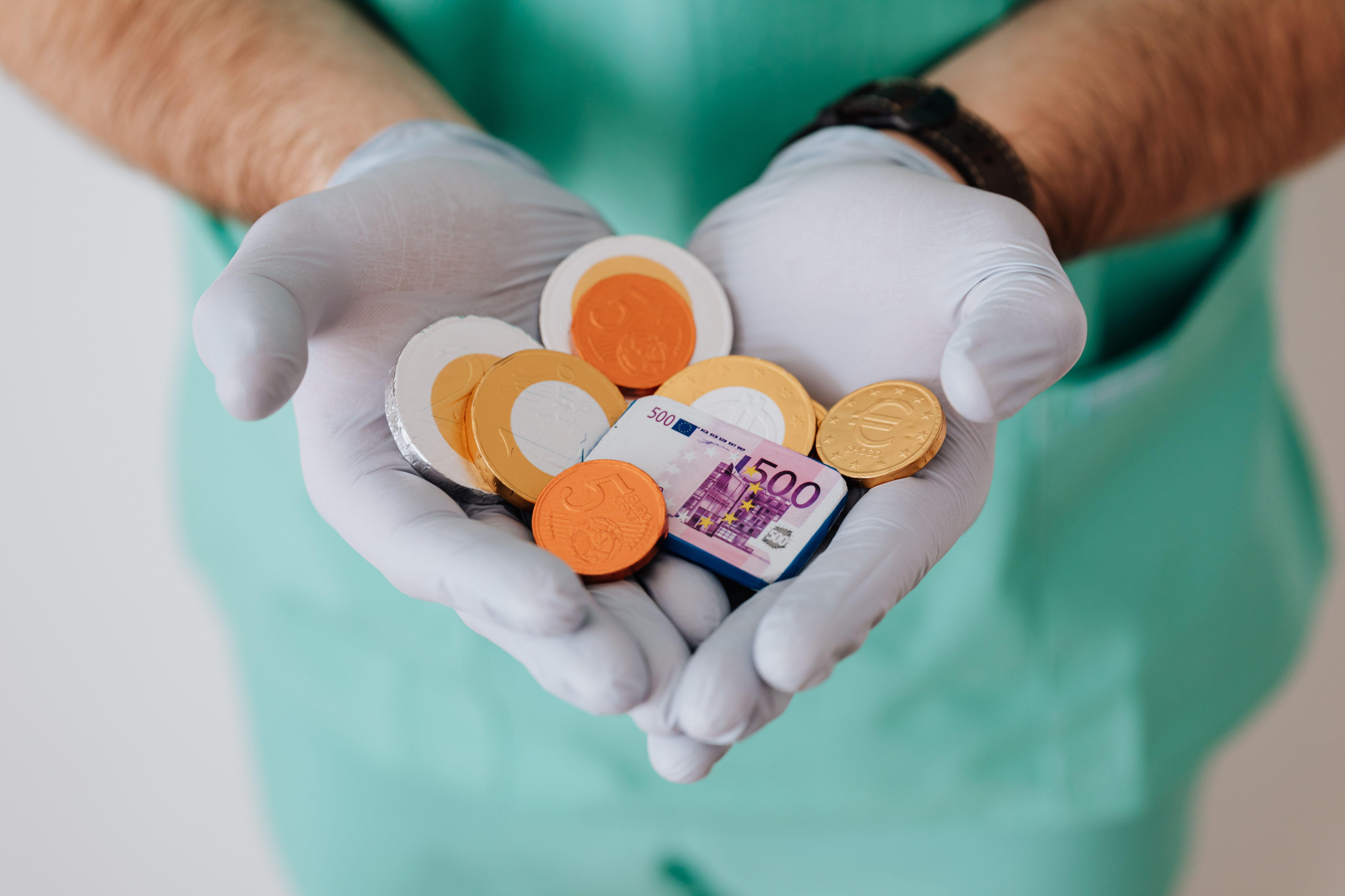 Mains de médecin tenant de l'argent factice
