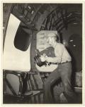 Photographie noir et blanc de 1946, montrant un photographe à bord d'un avion.