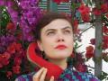 Rosemary Standley utilise une chaussure rouge comme combiné téléphonique.