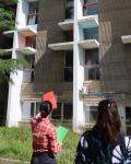 Manon Giovani, étudiante en Master médiation du Patrimoine lors d'une visite des oeuvres du campus Villejean, tenant dan ss amain des calques de couleur, pour présenter une oeuvre face à elle.