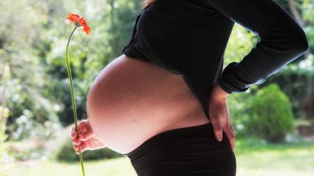 Photo d'une femme enceinte portant une fleur