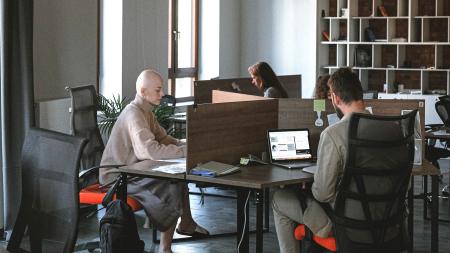 Espace de bureau en open space avec des collègues divers collaborant aux bureaux, design moderne