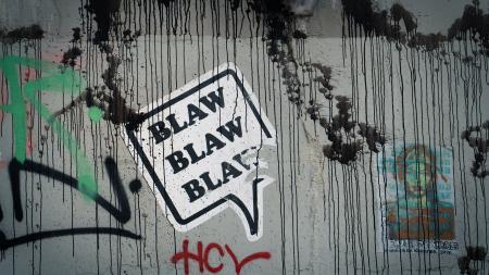 collage sur un mur dans la rue représentant une bulle de texte disant "blaw blaw blaw"