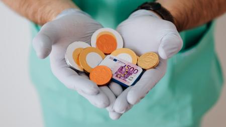 Mains de médecin tenant de l'argent factice