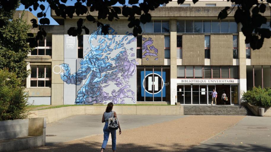 Vue de la bibliothèque universitaire, dont le mur est orné d'une fresque