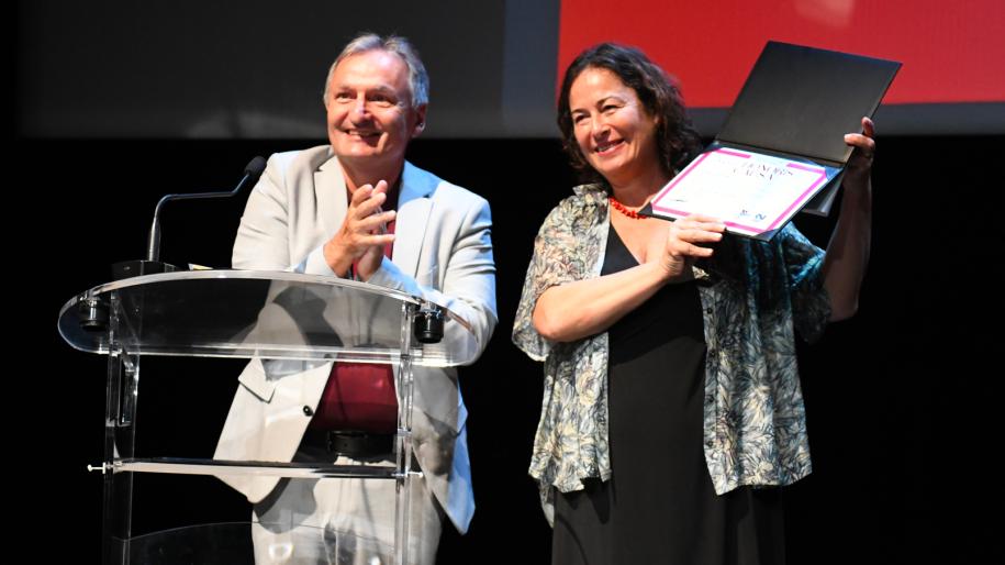 Vincent Gouëset et Pinar Selek montrant son diplôme au public