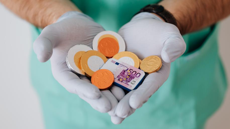 Mains de médecin tenant de l'argent factice