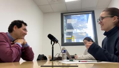 des étudiantes interviewent un professeur devant des micros