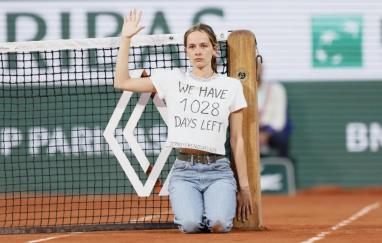 Photo d'une activiste portant un T-shirt "We have 1028 days left" ayant interrompu un match de Tennis à Roland-Garros