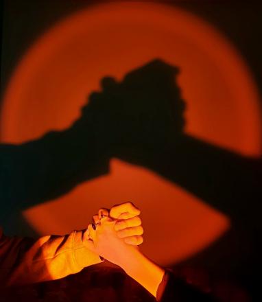 deux mains serrées sur un fond orange