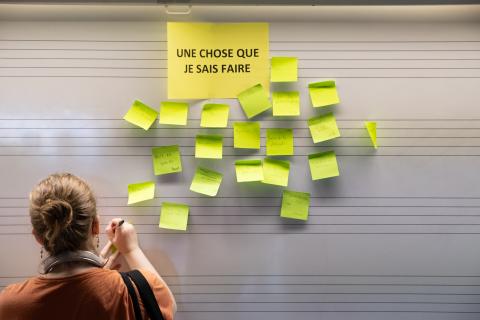 Quelqu'un colle un post it sur un mur