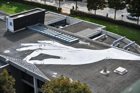 Fresque d'une main blanche sur un toit