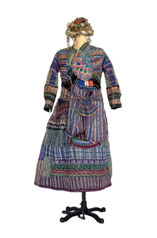 Robe traditionnelle richement brodée, aux motifs multicolores et rayés, présentée sur un mannequin, avec coiffe assortie, sur fond blanc.
