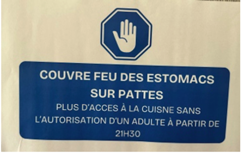 Photo d'un panneau "Couvre feu des estomacs sur pattes, plus d'accès à la cuisine sans l'autorisation d'un adulte à partir de 21h30"