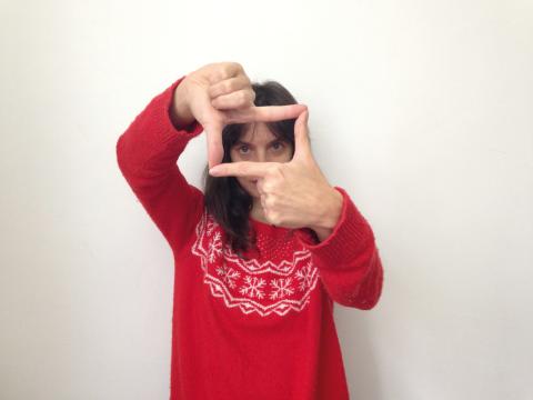 Photo d'une femme en pull rouge, qui avec ses mains cadre