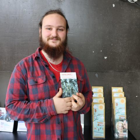 Marius Vialette, lauréat du concours "Faites court !" 2026, tenant le recueil de textes lauréats dans ses mains.